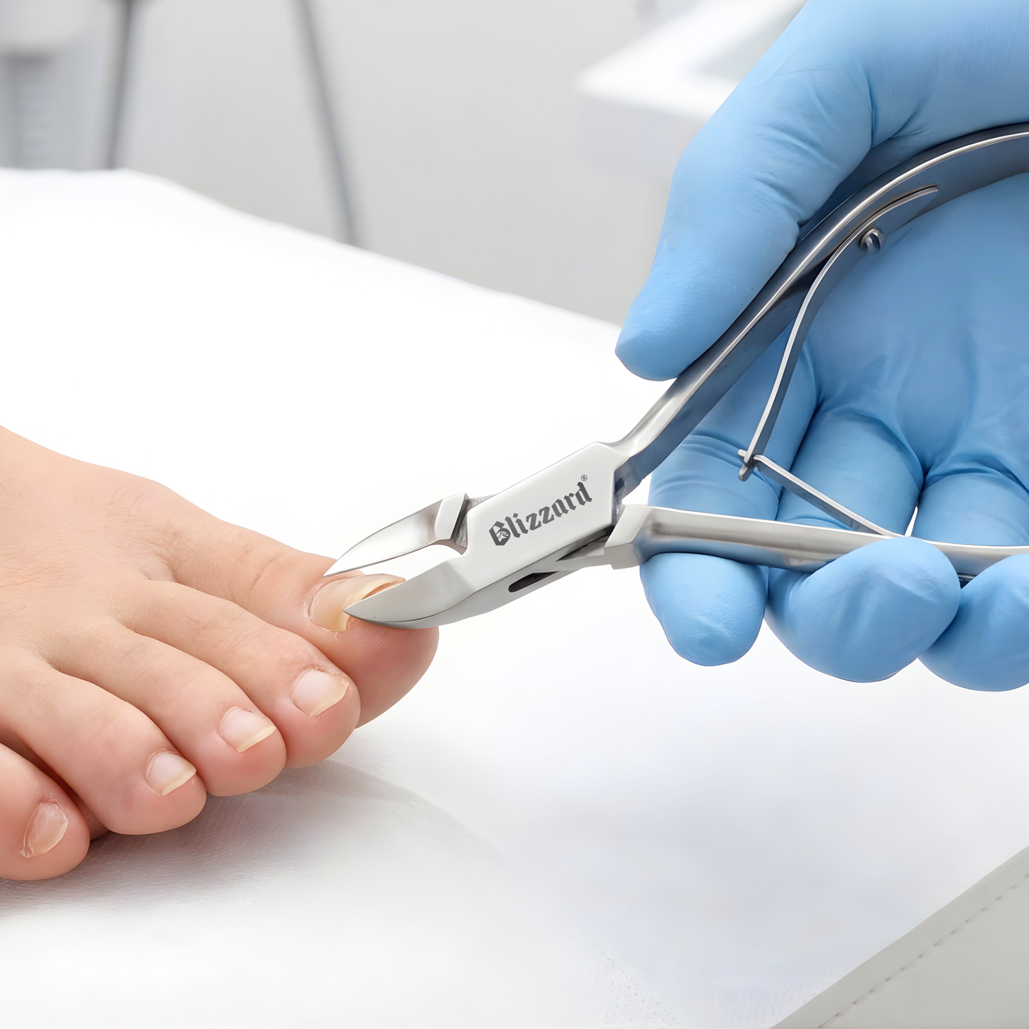 Person wearing blue gloves using Blizzard nail clippers on a foot.