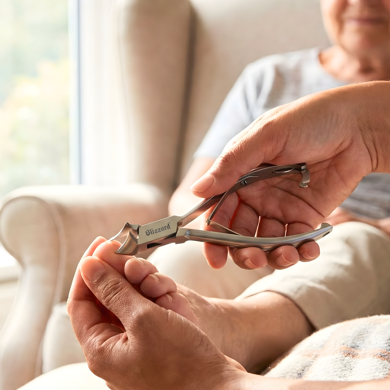 Person using a pair of nail clippers on another person's toes.